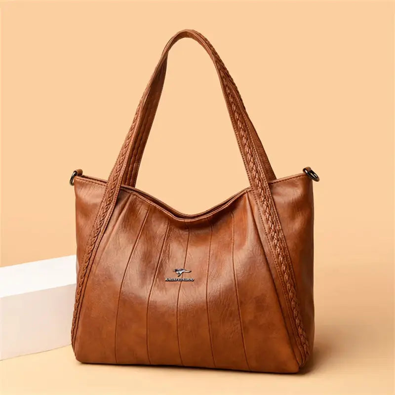 a brown leather handbag with braiding