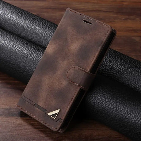 Brown leather wallet-style phone case with a metallic emblem.