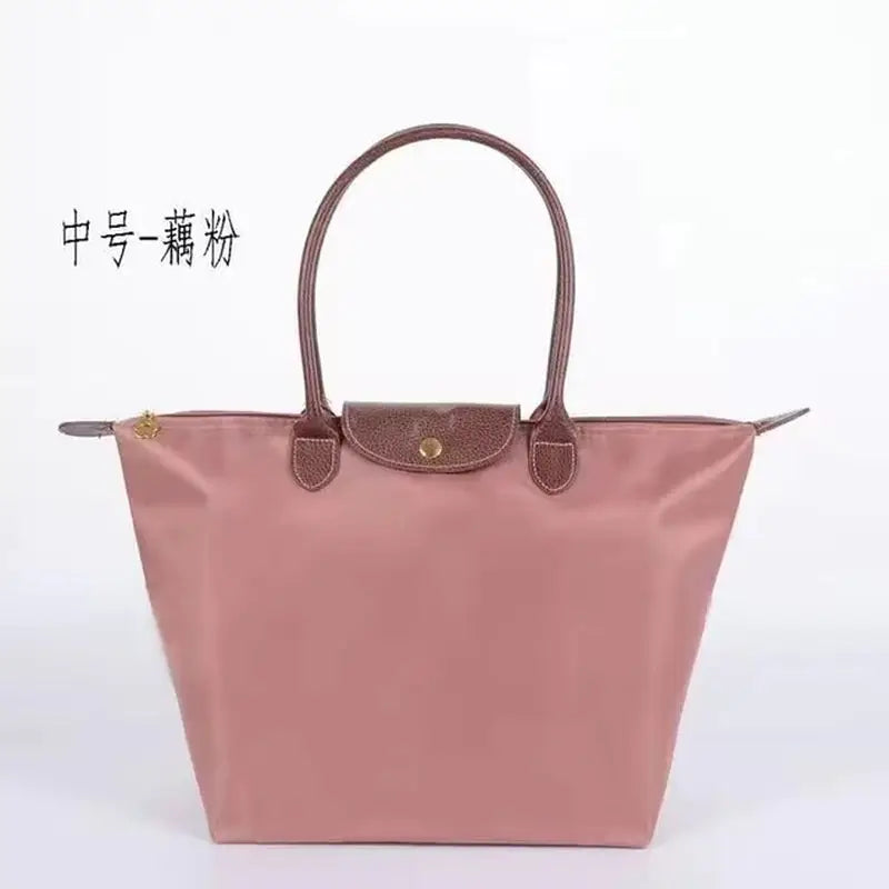 a pink handbag with a brown handle