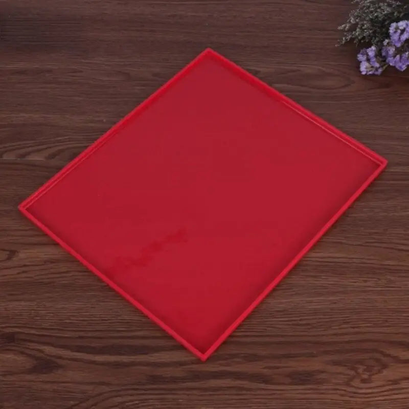 a red plastic cutting board on a wooden table