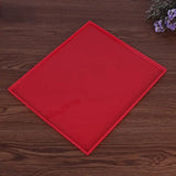 a red plastic cutting board on a wooden table