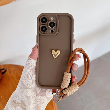 Brown phone case with gold heart and wrist strap.