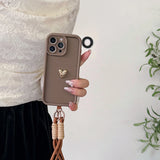 Brown phone case with heart charm and lanyard.