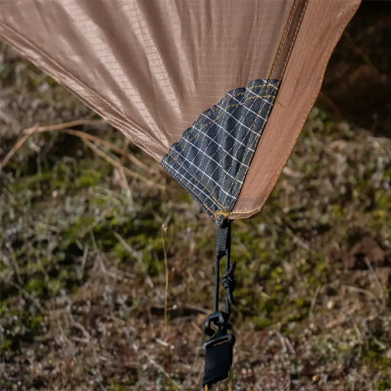 there is a brown tarp hanging from a tree in the woods