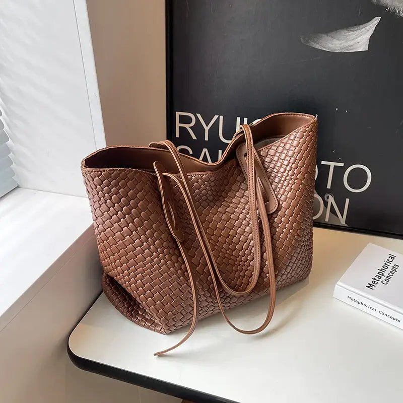 a brown woven bag on a white table