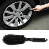 a car wheel brush with a hand holding it