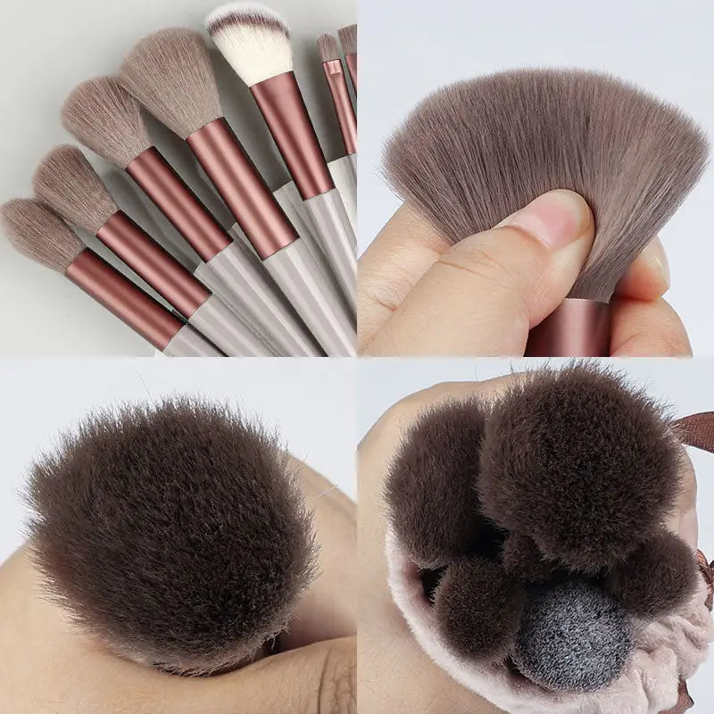 a close up of a person holding a bunch of makeup brushes