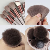 there are four different brushes in a hand with a cat’s paw