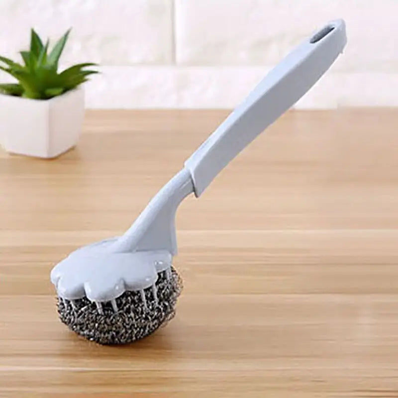 a brush on a wooden table with a plant in the background