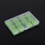 a green plastic box with six small round plastic discs