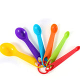 a bunch of colorful plastic spoons on a white background