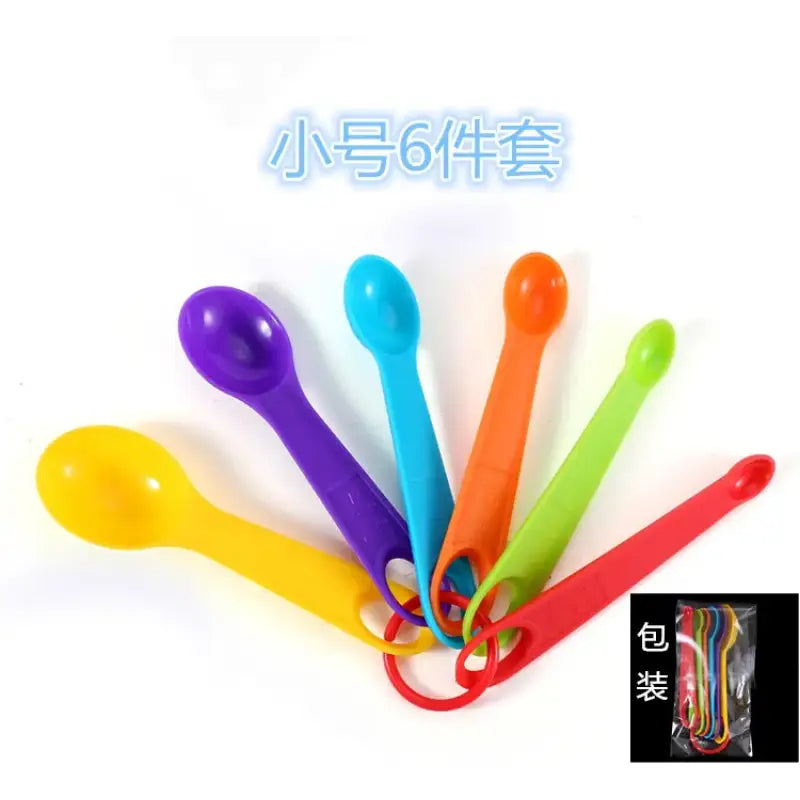 a bunch of colorful plastic spoons with a white background