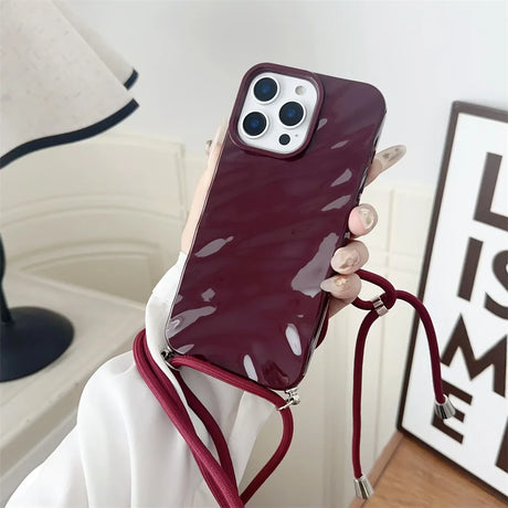 Burgundy phone case with crossbody strap.
