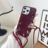 Burgundy phone case with crossbody strap.