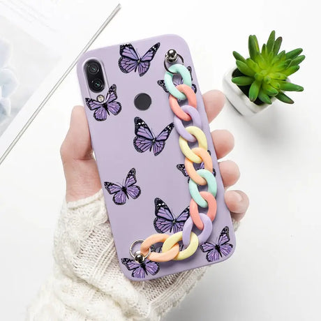 a woman holding a phone case with butterflies on it