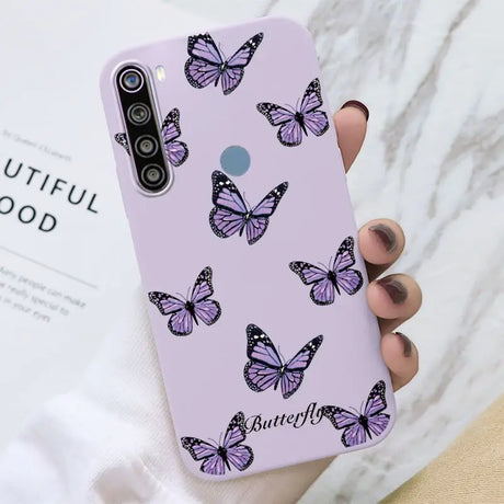 a woman holding a purple phone case with butterflies on it