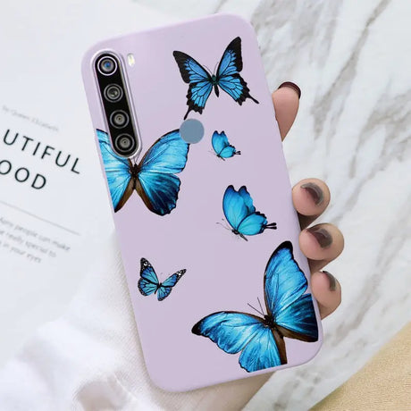 a woman holding a purple phone case with blue butterflies on it