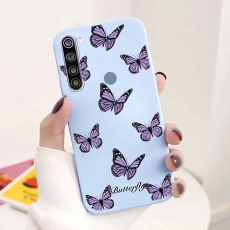 a woman holding a phone case with butterflies on it