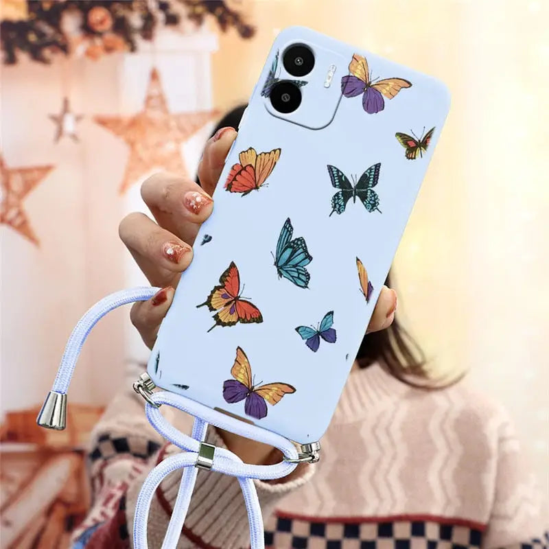 a woman holding a phone case with butterflies on it