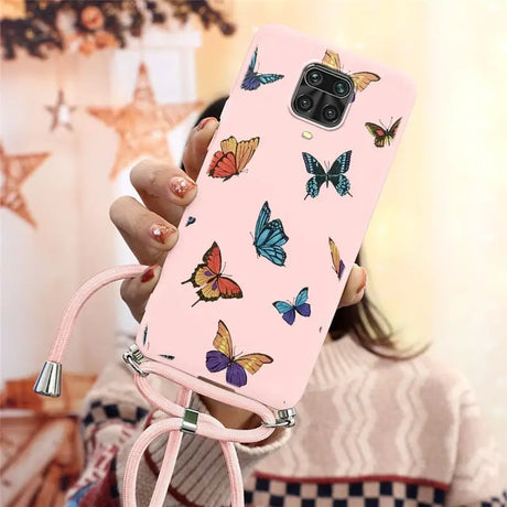 a woman holding a pink phone case with butterflies on it