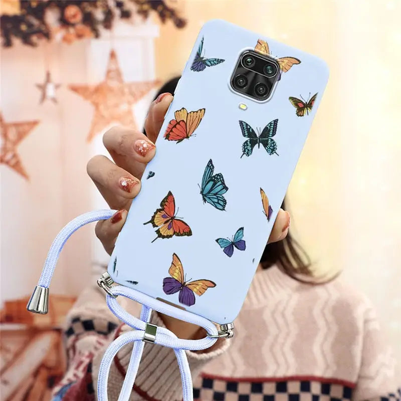 a woman holding a phone case with butterflies on it