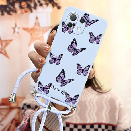 a woman holding a phone case with butterflies on it