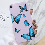 a woman holding a purple phone case with blue butterflies on it