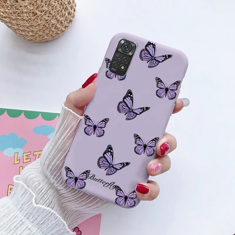 a woman holding a purple phone case with butterflies on it
