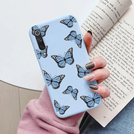 a woman holding a book and a phone case