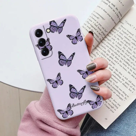 a woman holding a purple phone case with butterflies on it