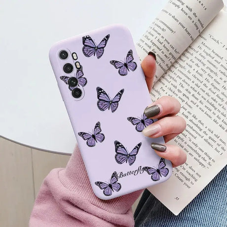 a woman holding a purple phone case with butterflies on it