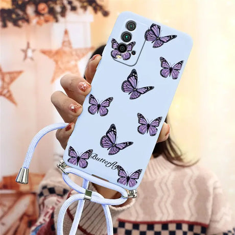 a woman holding a phone case with butterflies on it