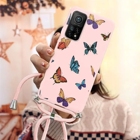 a woman holding a pink phone case with butterflies on it