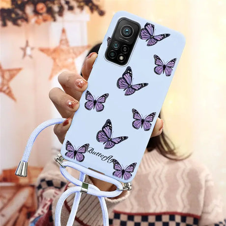 a woman holding a phone case with butterflies on it