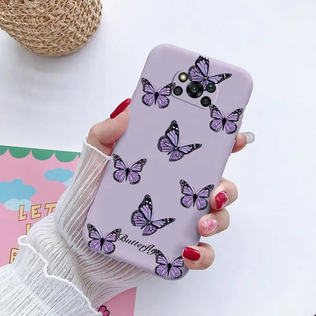 a woman holding a phone case with butterflies on it