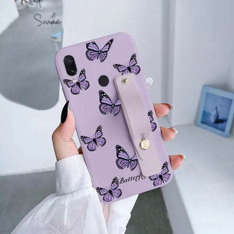 a woman holding a purple phone case with butterflies on it