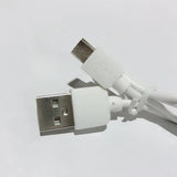 a close up of a white usb cable connected to a white phone