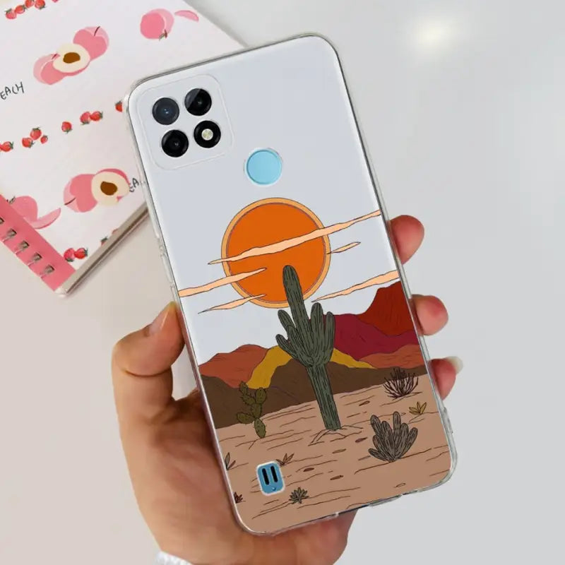 a hand holding a phone case with a desert scene