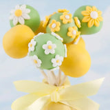 a cake pops with yellow and green frosting and white flowers