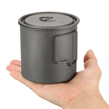 a hand holding a black canister