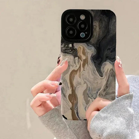 a woman holding up her phone case with a painting on it