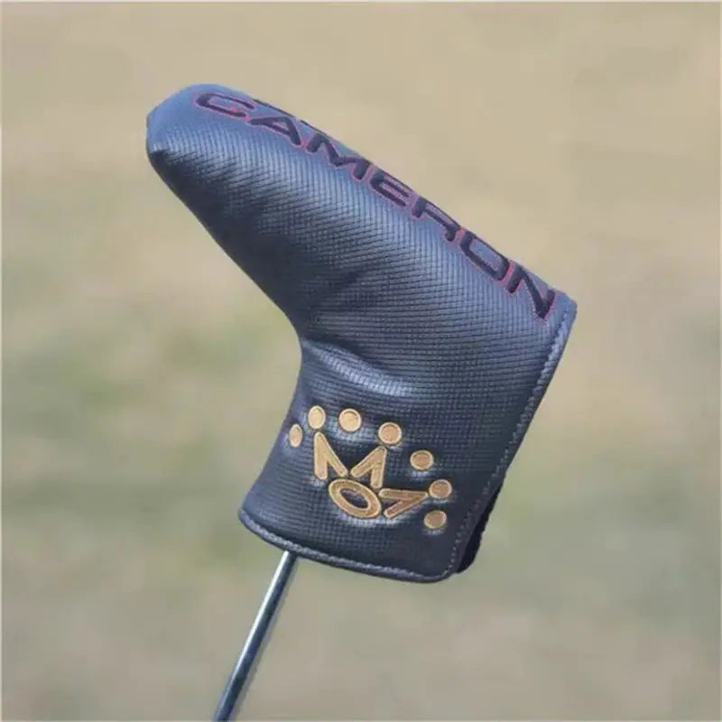 a golf club head cover with a gold logo