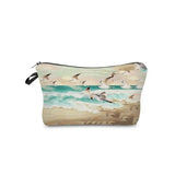 a small cosmetic bag with a painting of birds flying over the ocean