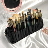 a black makeup brush holder with brushes and a mirror