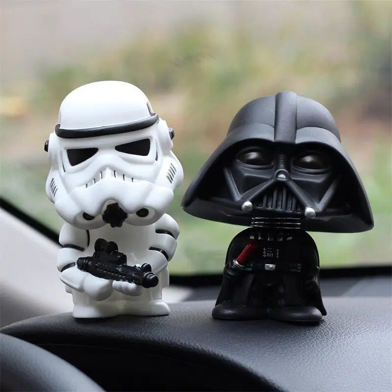 there are two star wars figurines on the dashboard of a car