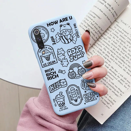 a woman holding a book and a phone case