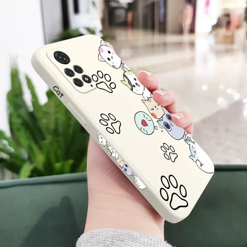 a woman holding a phone case with cartoon drawings on it