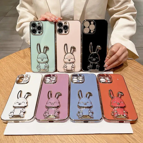 a woman holding a phone case with a rabbit on it