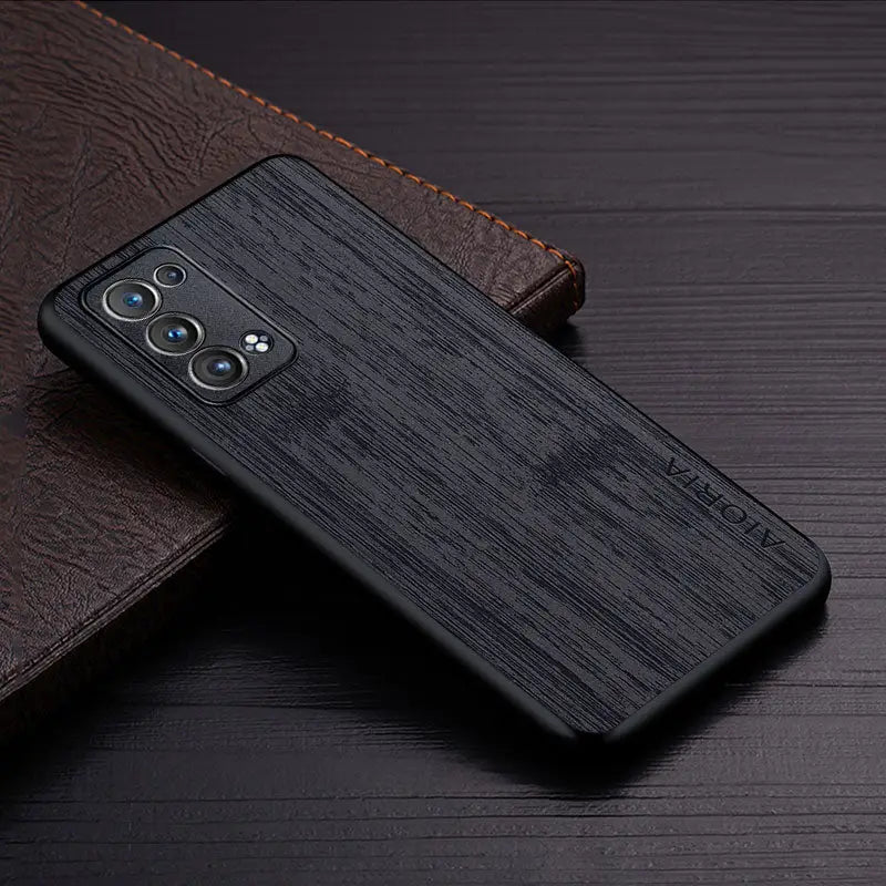 the back of a black iphone case on a wooden surface