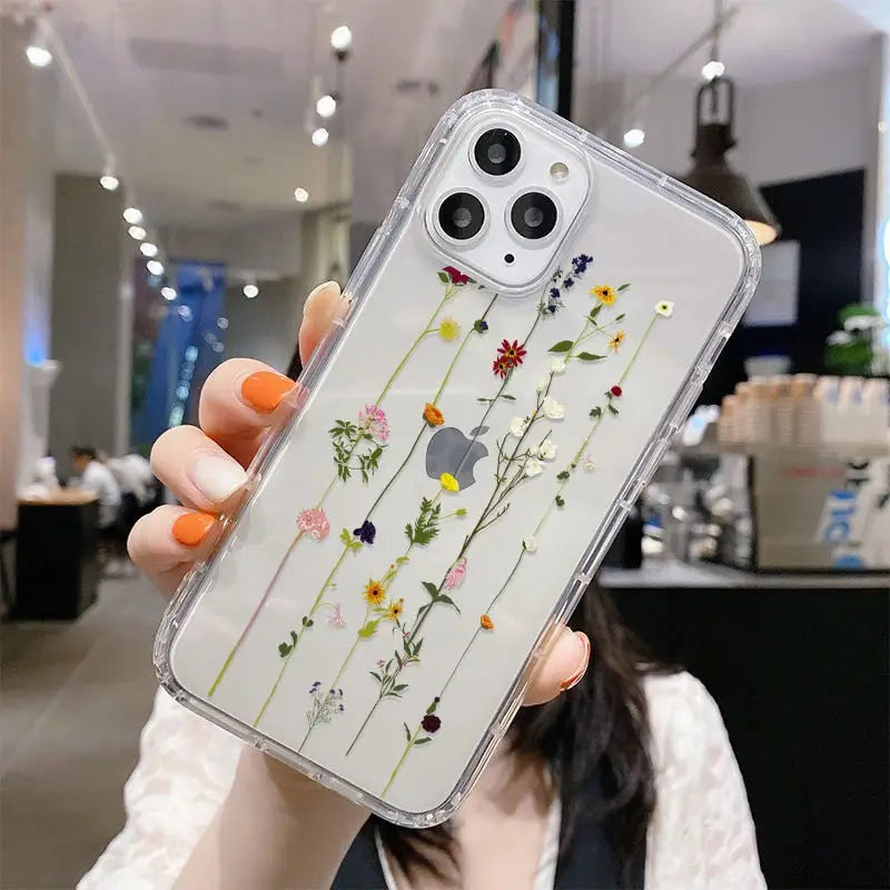 a woman holding up a clear case with flowers on it